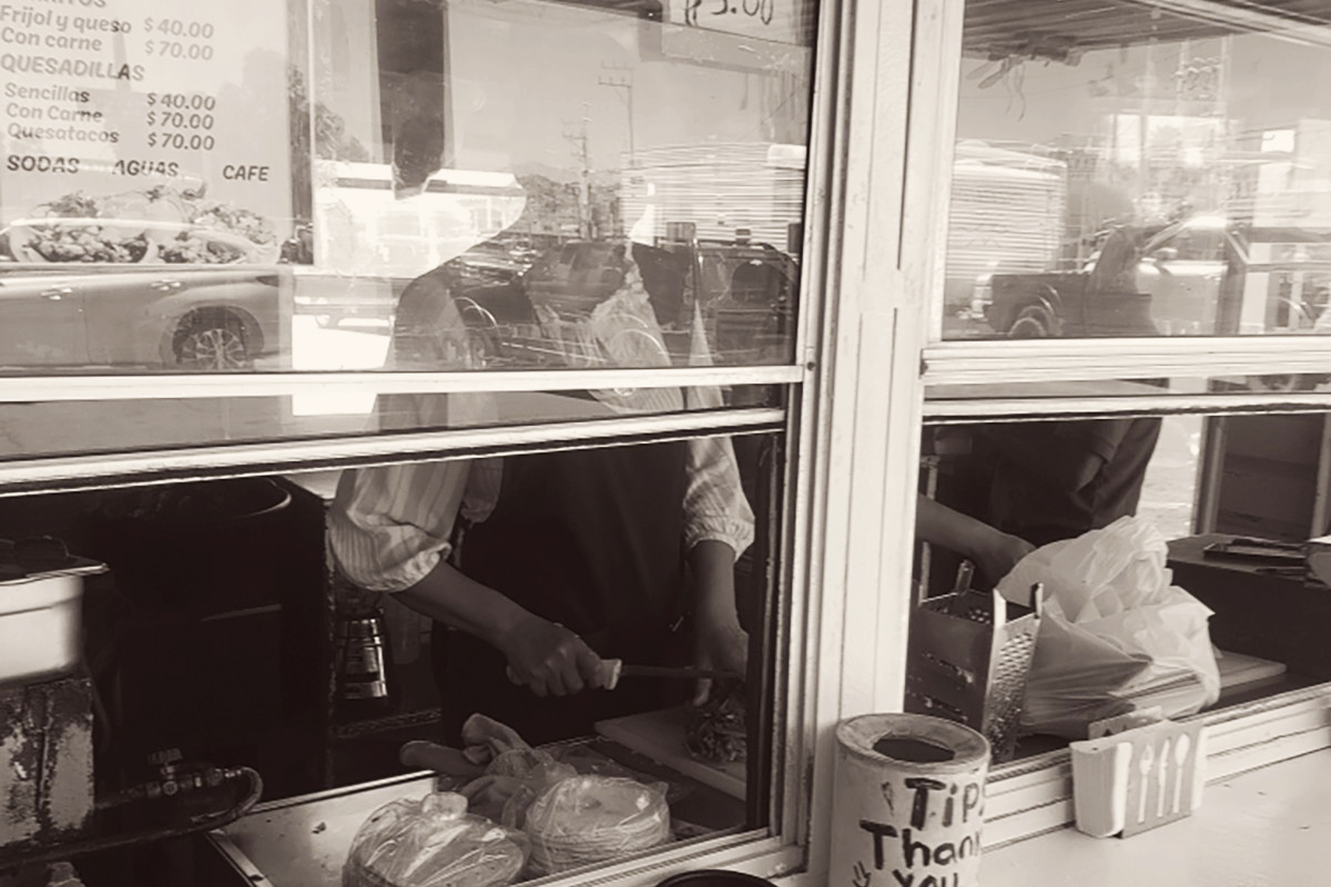 Women preparing tacos inside the food cart located in sonoyta mexico